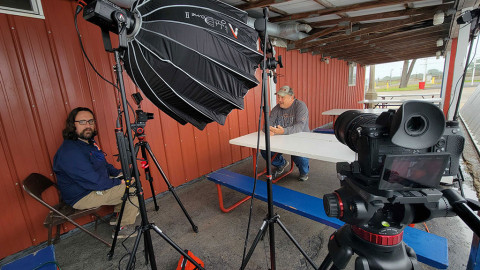 man interviews another man sitting at table