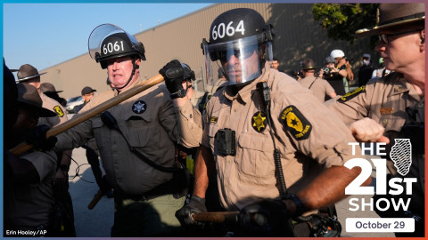 state troopers wear riot helmets and black gloves with padding on the knuckles, and brandish long wooden billy clubs face as they face off with demonstrators