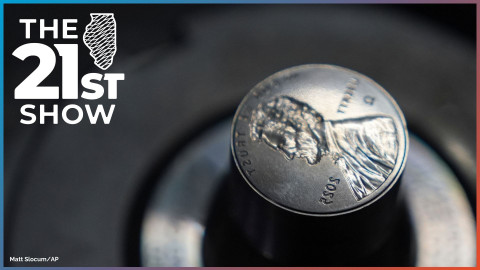 A dark gray cylinder of metal ends with the reverse image of the penny — the profile of Abraham Lincoln, plus LIBERTY, IN GOD WE TRUST, 2025, and the Greek letter omega.